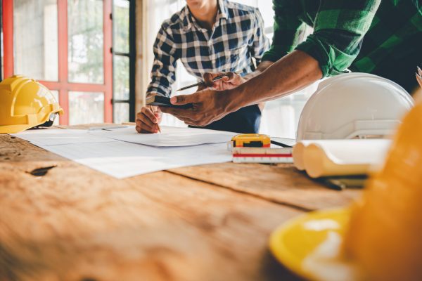 Engineers work as a team with blueprints for architectural plans. Engineer sketching construction project concept with architect equipment Architects talking at table Teamwork and construction concept