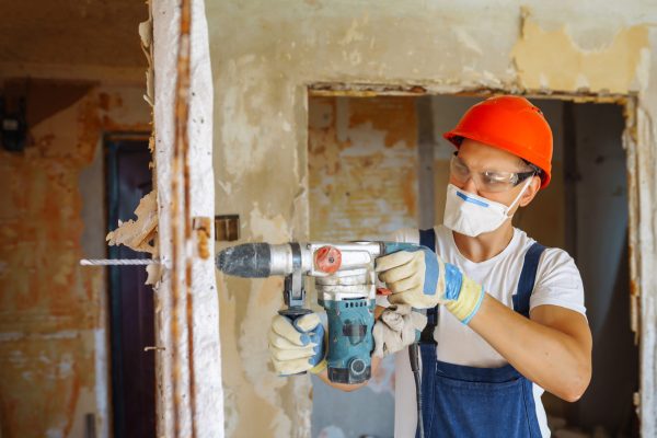Repairer in boilersuit holding tools. Apartment repair and renovation concept. Building.
