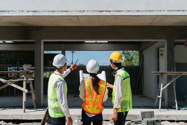 team engineer, foreman, architect meeting for colleagues discussing and checks construction blueprints at onsite.